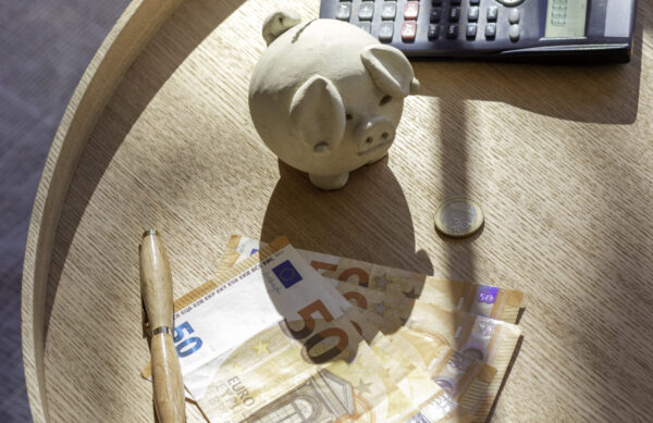Vertical view from above of cash money, wad of bills, coins and calculator for invesment concept at home
