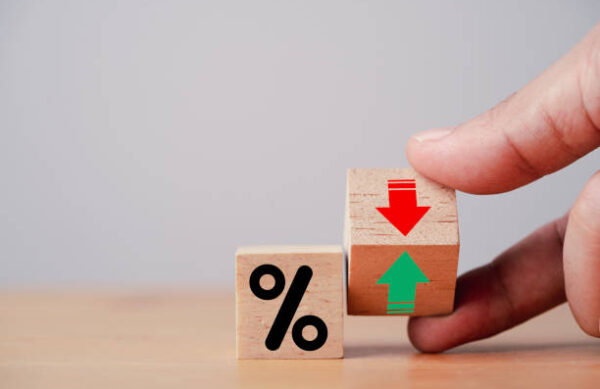 Hand flipping wooden cube block to change between up and down with percentage sign symbol for increase and decrease financial interest rate and business investment growth from dividend concept.