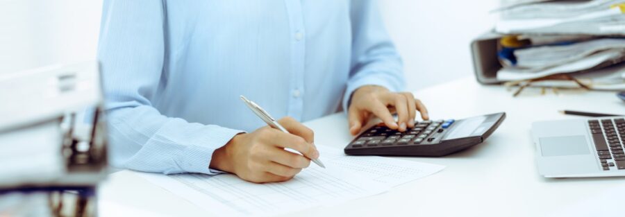 Professionnelle vérifiant des documents comptables avec une calculatrice